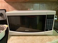 Front view of RCA microwave with visible keypad and door
