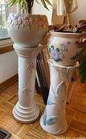 Full view of both ceramic plant stands and pots showing floral designs and relative sizes