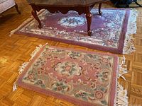 Two floral motif rugs on hardwood floor, one 53x33 inches area rug and one smaller 3x2 feet entry rug, both in mauve, beige, green and pink colors.