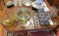 Wide view of the chip and dip bowls, metal caddy with tumblers, additional glasses, and other items on wood table