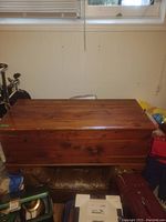 Closed cedar and pine wood chest with a smooth top and visible wood grain and knots.