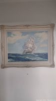Full view of the framed sailboat painting on the wall, showing size and framestyle.