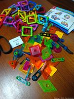 Magnetic shapes, gears, connectors, belts, and instruction booklet laid on table