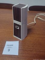 Side view of the lamp base with wood-tone panels and a switch