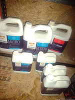 Photo shows mostly full 4L plastic jugs of Remo liquid nutrients including Micro, Bloom, and PastiFlower, as well as smaller containers of Grow nutrients.