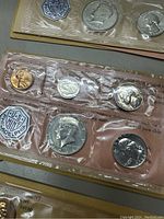 Close-up of sealed plastic blister holding 1963 proof set coins: Lincoln cent, Jefferson nickel, Roosevelt dime, Washington quarter, Franklin half dollar and US Mint medallion