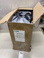 View of opened original cardboard box labeled Brookstone with mattress packed inside in carrying bag.