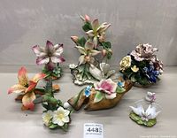 Overview of all porcelain items showing various flowers and birds including orchids, lilies, doves, and cluster arrangements