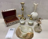 Full view of all items arranged showing the painted wooden box open, large stone ashtray, mother of pearl trinket pears, Lenox vase, brass candlestick, and stone ashtray with owl.