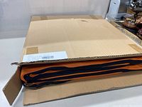 Box with orange fabric storage bag partially visible