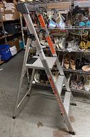 View of the step ladder fully opened, showing side rails, steps and rubber feet.