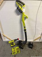 Full lot showing weedwhacker trimmer, cordless drill, drill bit set, charger, and two batteries.