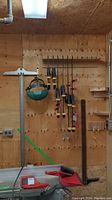 Overview photo showing all items mounted on wood wall including clamps, T-square, and face shield.