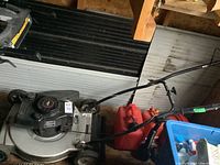 Eager-1 gas powered lawn mower sitting indoors on wooden floor.