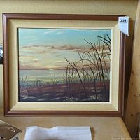 Full view of framed landscape painting with sunset sky and silhouetted vegetation in the foreground.