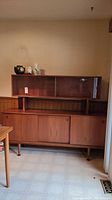 Full front view of teak sideboard with hutch against wall