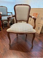 Full view of the armchair showing the exposed wood frame and blue and white gingham upholstery on seat, back, and arms