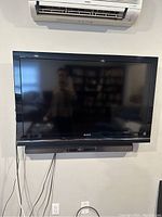 Samsung 46-inch flat screen TV mounted on the wall with visible power and channel buttons on side panel.