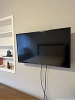 Full front view of Toshiba 32-inch LED HDTV mounted on wall showing screen and surroundings