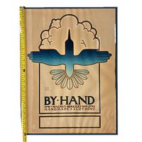 Photo of framed By Hand Berkeley clothing shop poster showing bird image, text and frame.