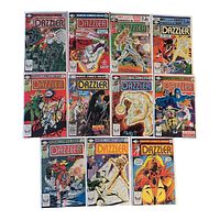 Photo showing 11 vintage Dazzler comic books from Marvel Comics Group, arranged in rows. Covers include prominent Marvel logos and feature Dazzler with various comic characters and scenes.