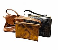 Three vintage handbags displayed together: brown crocodile texture bag, brown marbled leather bag, and black crocodile texture bag.