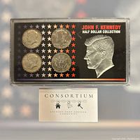 Front side of four John F. Kennedy half dollar coins mounted in a display case with a colored insert featuring Kennedy's profile and title text.