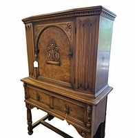Front and side view of the vintage revival style wooden cupboard showing carved floral decoration and sturdy legs.