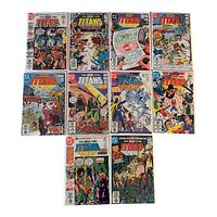Photo showing group of 10 Teen Titans comic books, each in plastic sleeves, arranged in two rows on white background. Covers feature different action scenes and vibrant colors typical of classic DC Comics comic books.
