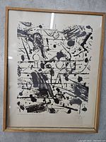 Full view of framed abstract black ink artwork with visible signature and water damage at bottom.