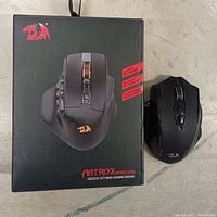 Redragon Aatrox Wireless MMO gaming mouse alongside its boxed packaging, showing the mouse with RGB lighting on the scroll wheel and its button layout.