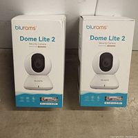 Two Blurams Dome Lite 2 security camera boxes showing front product image and brand logos.