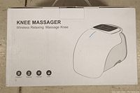 Box packaging displaying knee massager image and listed features: vibration, heating, infrared, laser