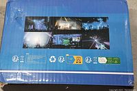 Box exterior showing blue packaging with performance event images and recycling icons.