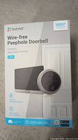 Box of EZVIZ Wire-free Peephole Doorbell CP4 showing branding, 1080p resolution, and features like rechargeable battery and human motion detection.