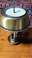 Full view of the vintage brass table lamp showing the base, central column, and shade with mesh insert.