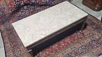 Top view of rectangular vintage coffee table showing the full marble top and wooden frame with some wear.