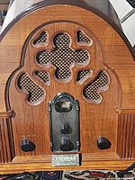 Front view of vintage Thomas Cathedral wooden radio with carved grille and mesh speaker cover