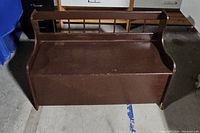 Brown wooden storage bench with a hinged seat for lifting showing the top and front.