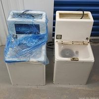 Two Azuradisc 1600 disc cleaning machines side by side, one covered in blue plastic protective sheet.