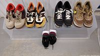 Five pairs of vintage and modern sneakers arranged showing top and side views, featuring Nike and New Balance brands.