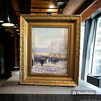 Full front view of framed painting displayed resting on table showing carved gilt wood frame and snowy street scene