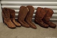 Three pairs of brown women's cowboy boots, arranged side by side showing overall appearance and color variations.