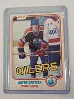 Front of the 1980-81 Wayne Gretzky O-Pee-Chee hockey card showing Gretzky in Oilers uniform holding hockey stick.