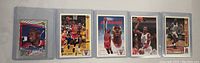 Photo showing 5 Michael Jordan basketball cards in protective sleeves, arranged in a row.