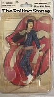 Front view of action figure in packaging showing Mick Jagger figure in blue polka dot jumpsuit with white boots, clear plastic blister packed to a card backing with large Rolling Stones red lips logo
