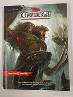 Front cover of the Out of the Abyss Dungeons & Dragons book showing demonic creatures and title.