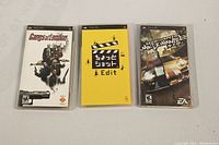 Front view of three PSP game cases: Gangs of London, Japanese game 'Edit' with yellow cover, and Need for Speed Most Wanted 5-1-0.