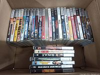 Box with 30 PSP UMD movie cases lined up side by side.