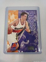 Front of Steve Nash rookie card with Phoenix Suns uniform, 'Rookie' text, and team logo.
